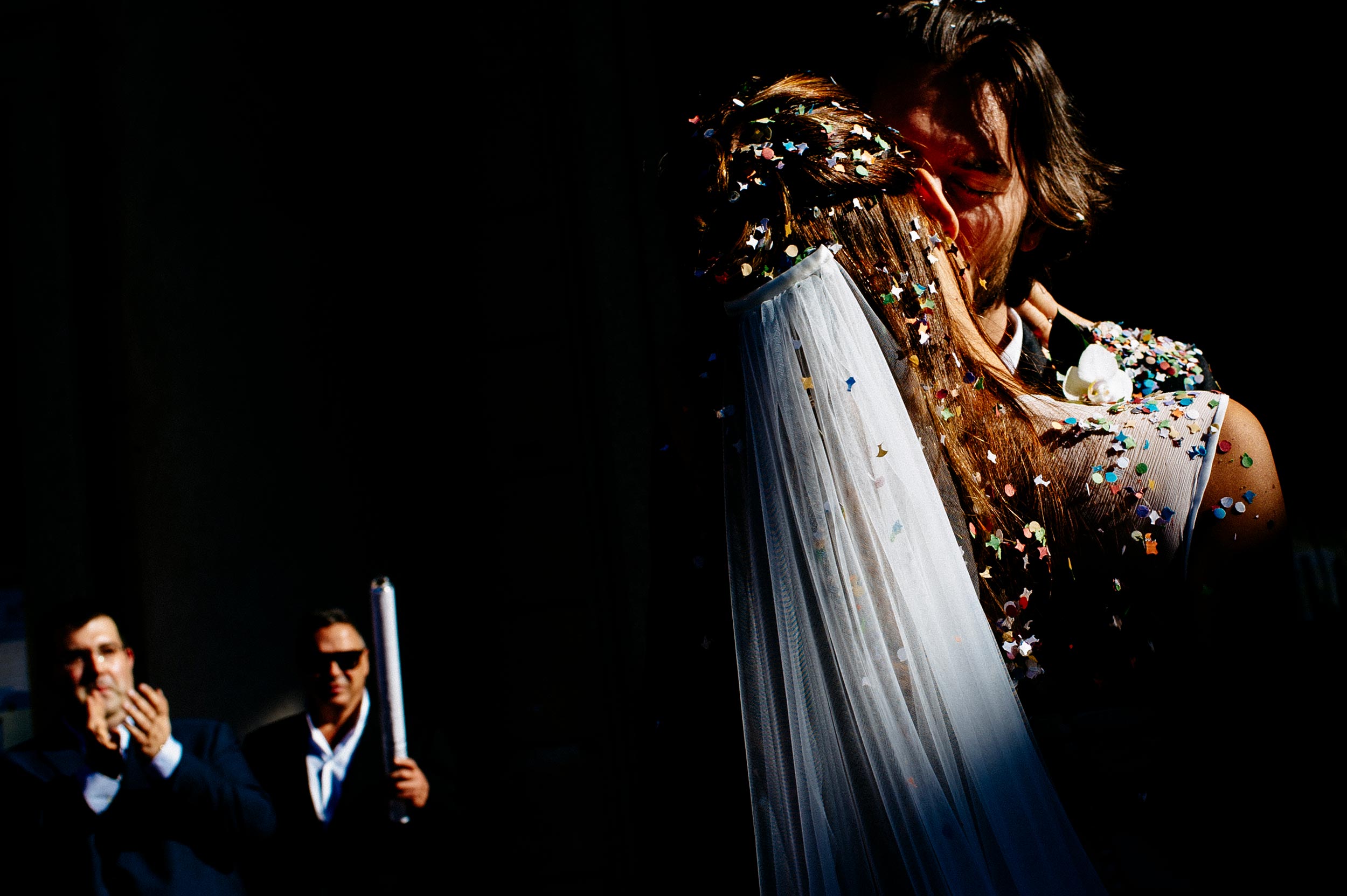 the bride and groom kissing outside the church with confetti on them