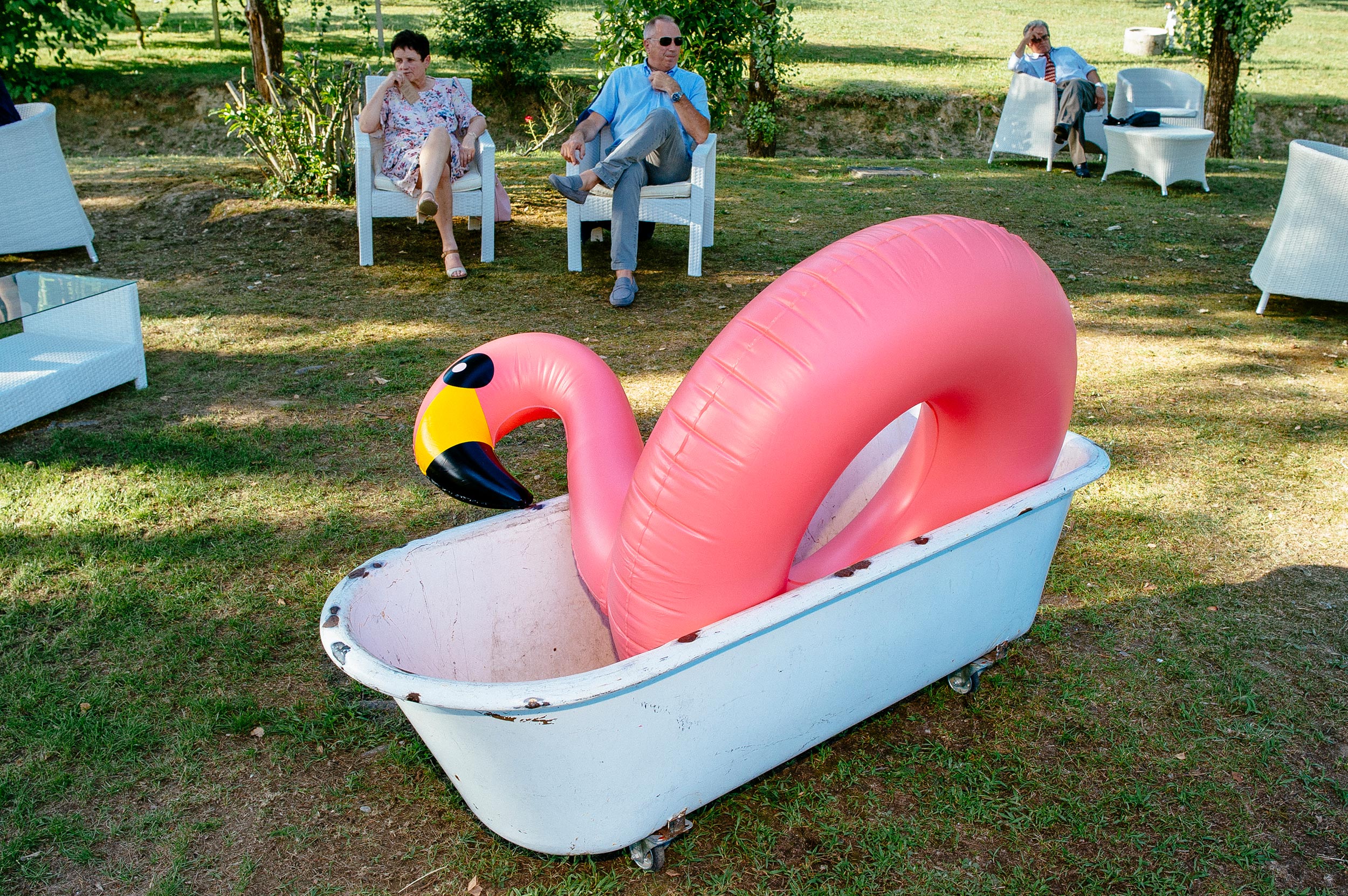 pink flamingo sitting in a bathtub on the grass during wedding reception italy