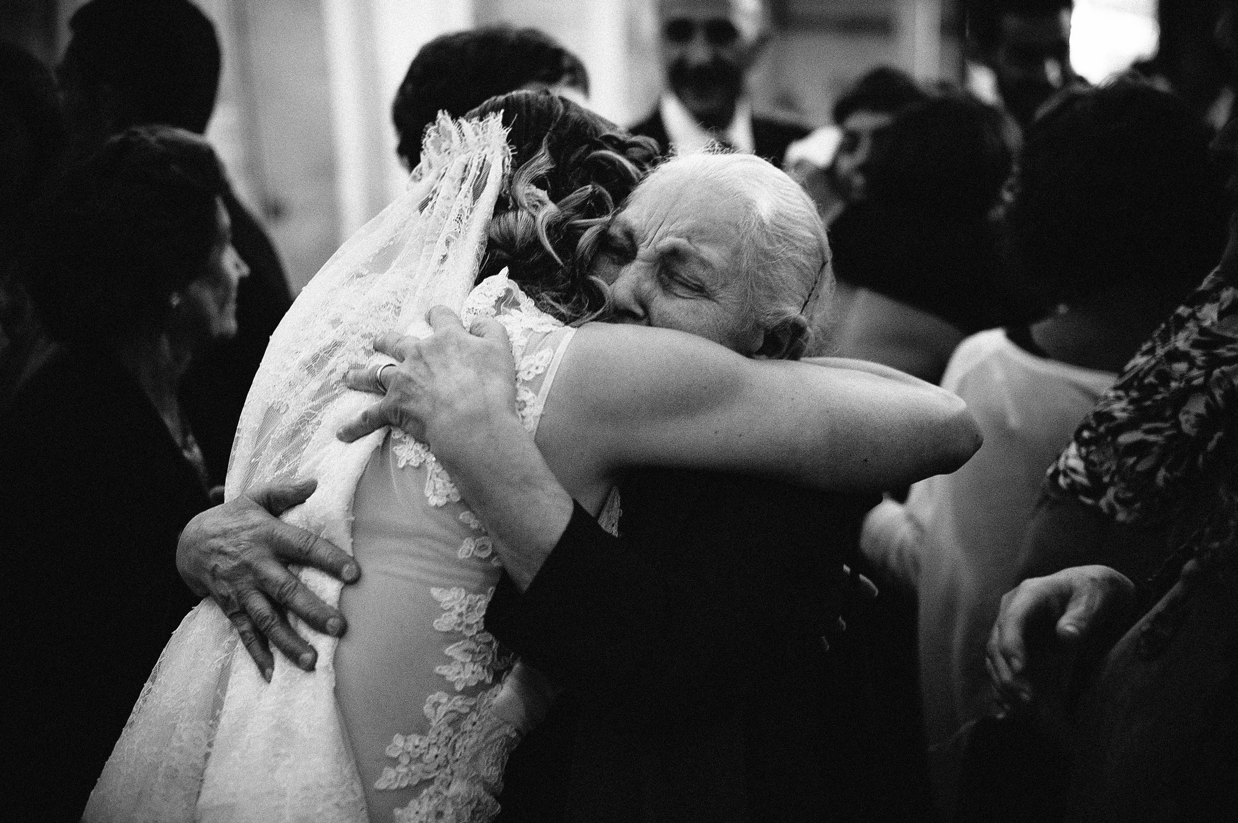 the bride hugs her grandmother after the reception italy black and white wedding photography