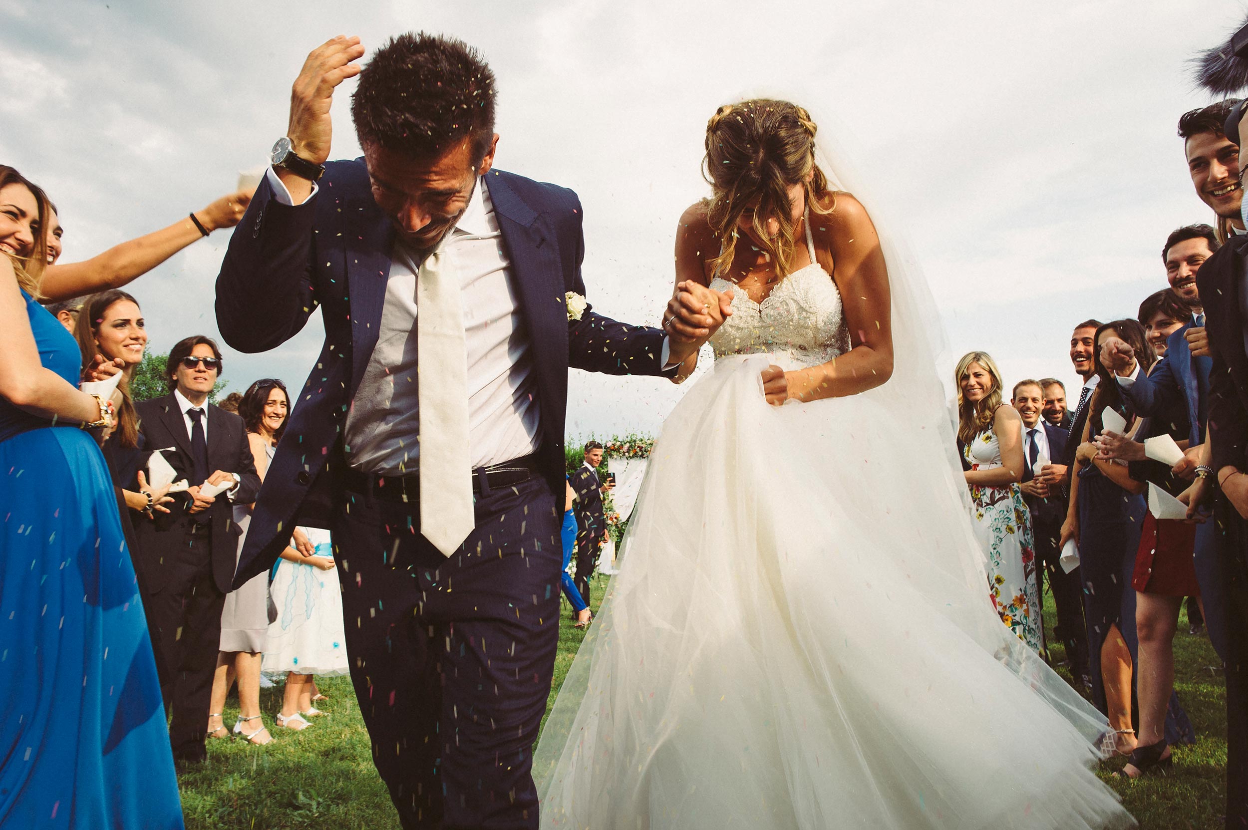 wedding ceremony garden italy bride and groom running confetti rice documentary wedding photography by Alessandro Avenali