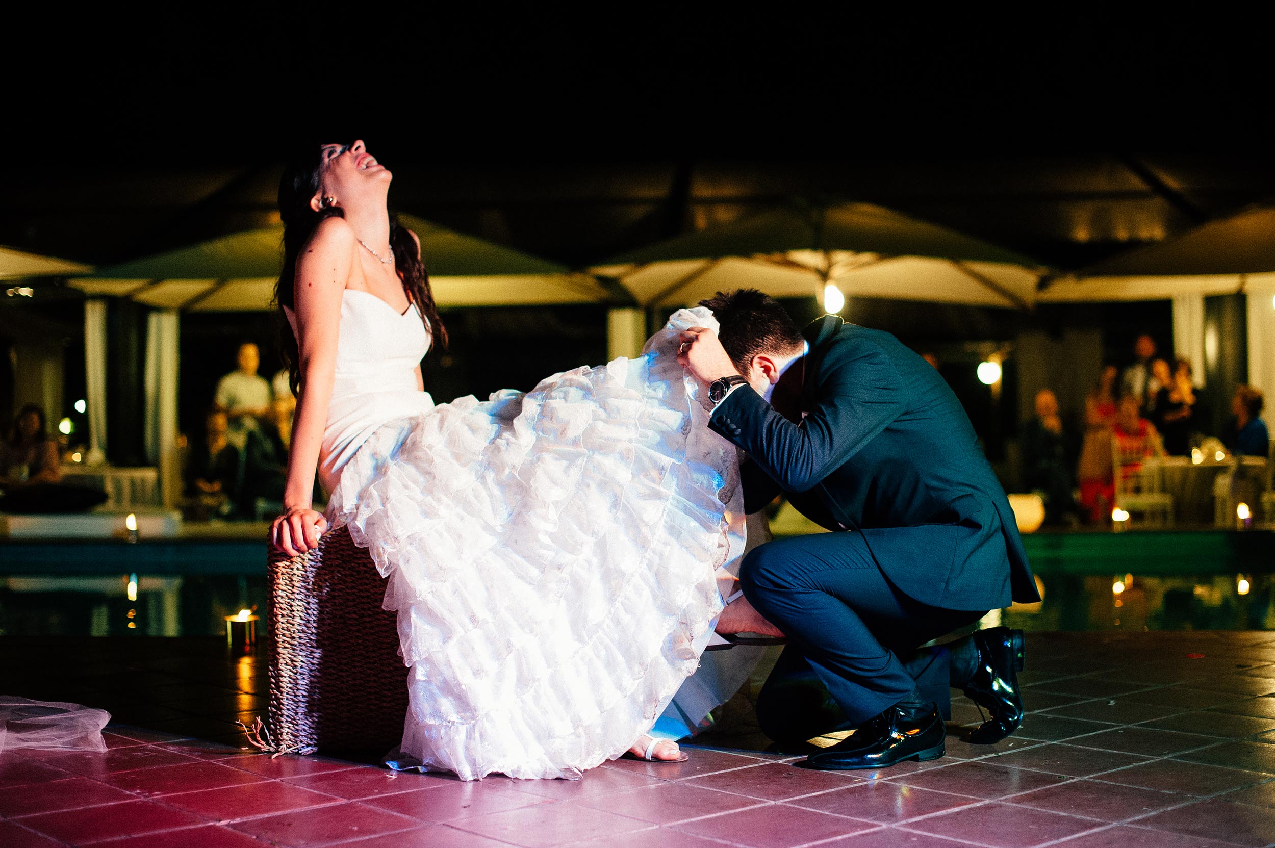 groom looking under brides wedding dress aiming for the garter