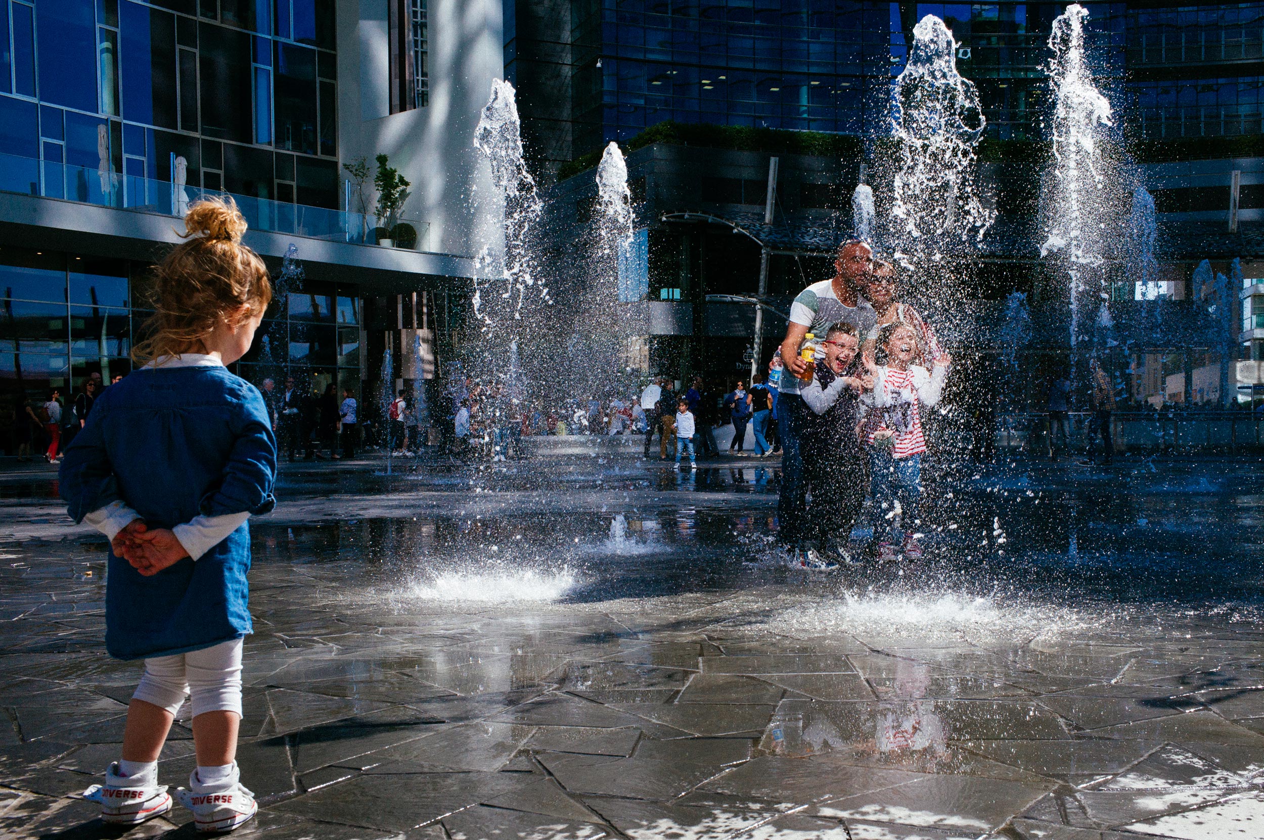 Milan Italy - Little girl stares at a family taking group photo